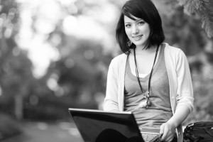 Mixed race college student working on laptop at campus